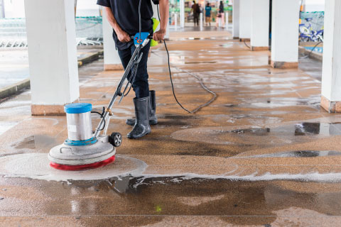 Reinigungskraft säubert den Boden auf einer Baustelle – Außen- und Baustellenreinigung durch SMG