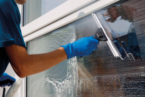 Reinigungskraft säubert ein großes Fenster – professionelle Glas- und Fassadenpflege durch SMG
