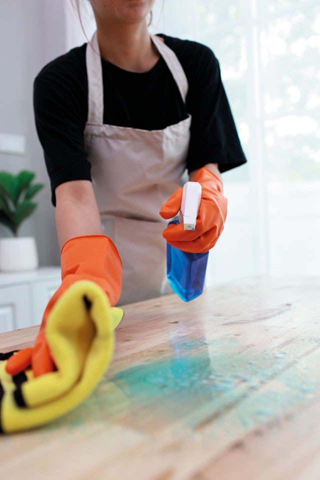 Reinigungskraft wischt mit Tuch und Reinigungsmittel – erfahrene Gebäudereinigung durch SMG