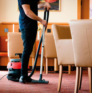 Person beim Staubsaugen in einem gepflegten Objektbereich – professionelle Gebäudereinigung von SMG